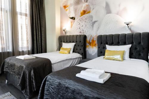 two beds in a hotel room with towels on them at Corner House in Lovech