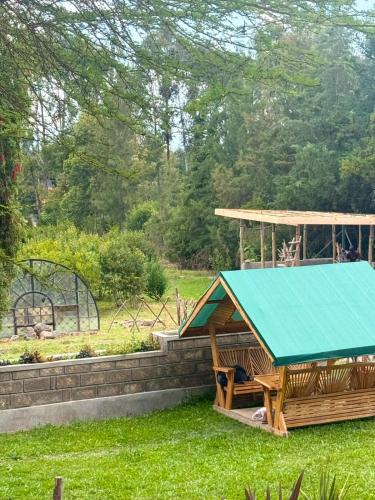 a gazebo with a blue roof in a yard at Serenity Glamping By Rafiki in Nanyuki