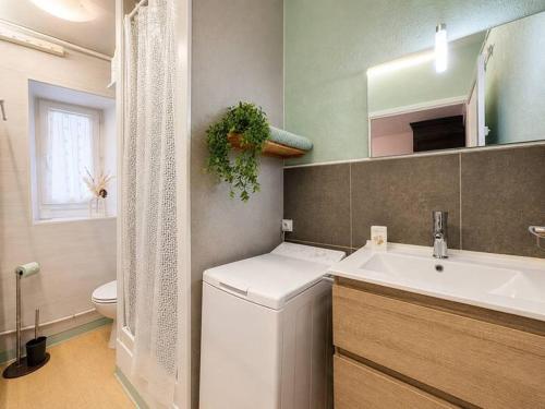 a bathroom with a white sink and a toilet at Azur des jardins in Annonay