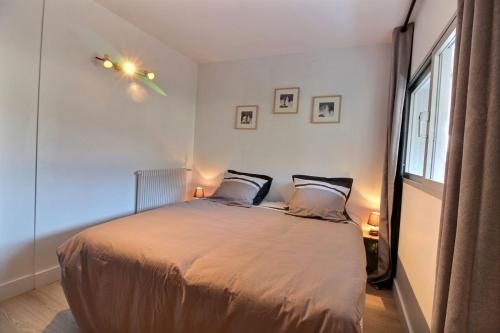 a bedroom with a bed with two pillows and a window at Le port in Perros-Guirec
