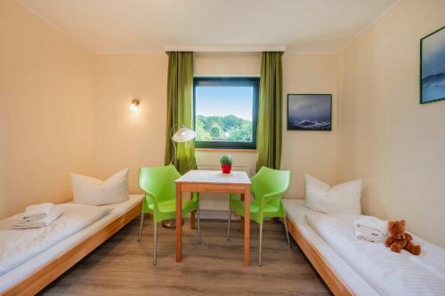 a room with two beds and a table and chairs at Lindenstraße Ferienwohnung Anker in Koserow