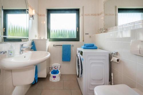 a white bathroom with a sink and a toilet at Lindenstraße Ferienwohnung Anker in Koserow