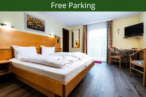 a hotel room with a large bed and a tv at Hotel Restaurant Freihof in Oberharmersbach