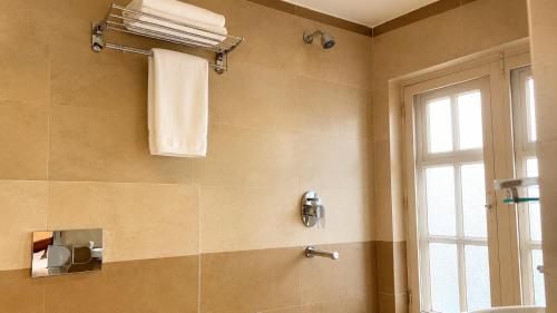 a bathroom with a shower with a sink and a window at Suva Garden Hotel in Kathmandu