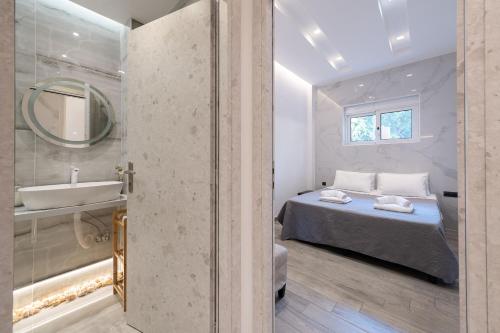 a bedroom with a bed and a sink and a mirror at Luxury Black and White Interior Apartments & Rooftop Terrace in Kalamata