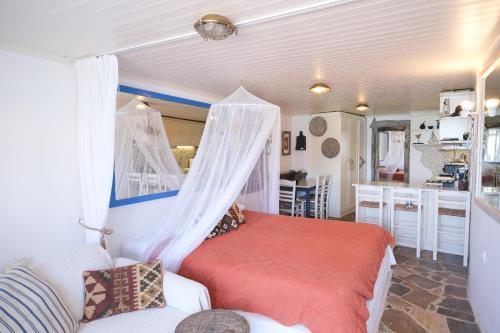 a bedroom with a bed and a couch in a room at Paradiso in Firopótamos
