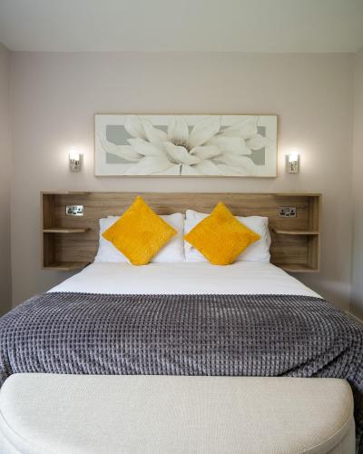 a bedroom with a large bed with yellow pillows at Mountain View Cottages in Tralee