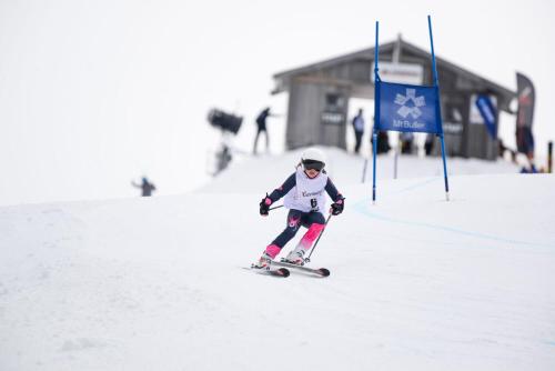a young girl is skiing down a snow covered slope at Ski Club of Victoria - Kandahar Lodge in Mount Buller