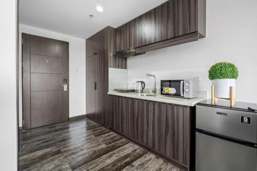 a kitchen with wooden cabinets and a counter top at Espacio Hotel in Manila