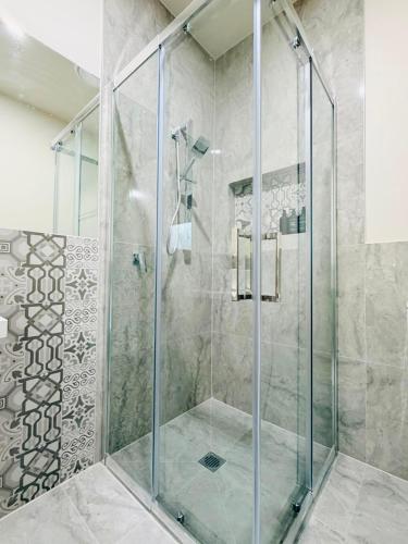 eine Dusche mit Glastür im Badezimmer in der Unterkunft Premier Suite with Private Bathroom in Wyndham Vale