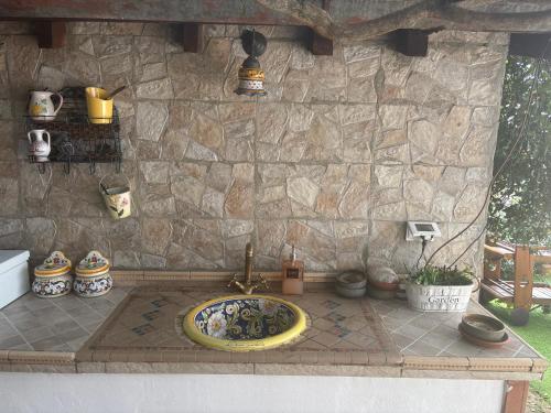 a bathroom with a sink in front of a stone wall at B&B IL TULIPANO free private parking in Como