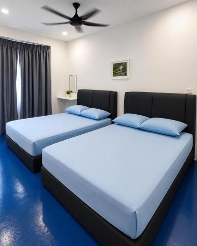 two beds sitting next to each other in a bedroom at CZi BOUTIQUE HOTEL SG SIPUT in Sungai Siput