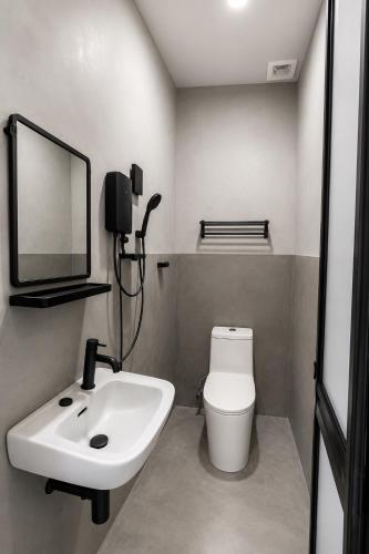 a bathroom with a sink and a toilet and a mirror at CZi BOUTIQUE HOTEL SG SIPUT in Sungai Siput