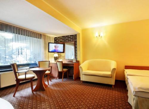 pokój hotelowy z łóżkiem, stołem i krzesłami w obiekcie Hotel Astra Tajemniczy Ogród w Poznaniu
