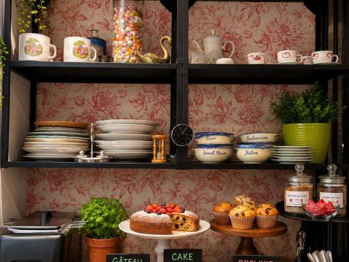 a shelf filled with plates and cups and dishes at Greet hôtel Saint-Nazaire-Trignac, Nouvelle marque du groupe Accor in Saint-Nazaire
