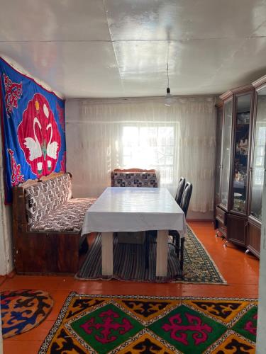 a dining room with a table and a couch at Ademi Art in Kyzart