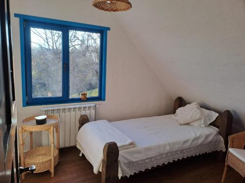 a bedroom with a bed with a blue window at Maramureș Nook in Comarnic