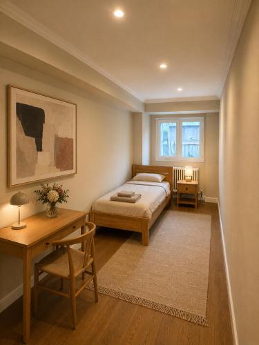 a bedroom with a bed and a table and a desk at Art Residence, Beat Schild in Brienz