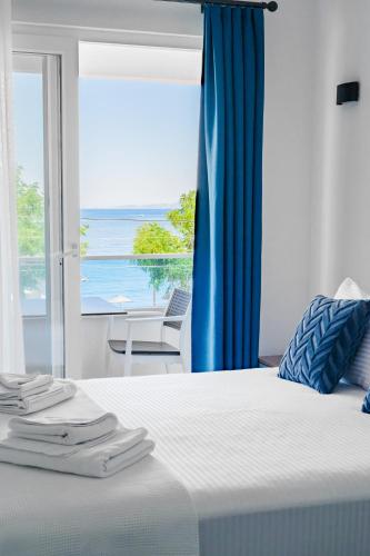 a bedroom with a bed with a view of the ocean at ADAYELI BUTIK HOTEL in Karaburun