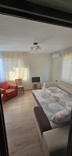 a bedroom with a large bed and a couch at Къща за гости ЧЕРИ in Tryavna