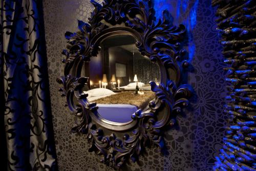 a mirror on a wall with a bed in a room at The Crystal Blue Hotel in Athens
