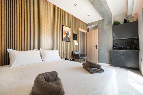 a bedroom with a bed with towels on it at Luxury Black and White Interior Apartments & Rooftop Terrace in Kalamata