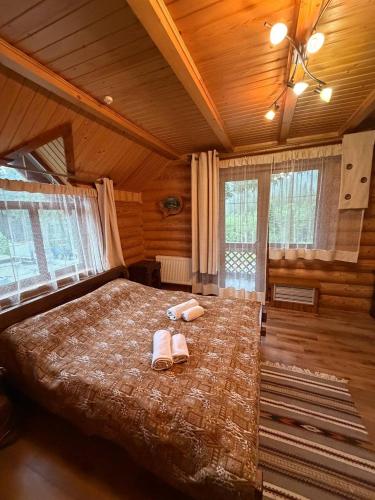 a bedroom with a large bed with two slippers on it at Дикий Кіт in Vorokhta