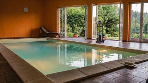 a swimming pool in a house with windows at Hide Away in a Private Countryside Villa in Prestranek