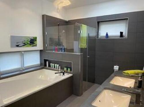 ein Badezimmer mit Badewanne, Waschbecken und Badewanne in der Unterkunft LaLuna - Ruhe & Behaglichkeit am Stadtrand von Köln - in Lohmar