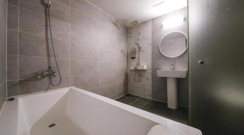 a bathroom with a bath tub and a sink at cs프라자호텔 in Cheonan