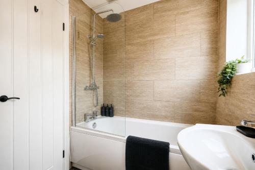 a bathroom with a bath tub and a sink and a bath tub at Beautiful Abode in The Bath Cotswolds in Frome