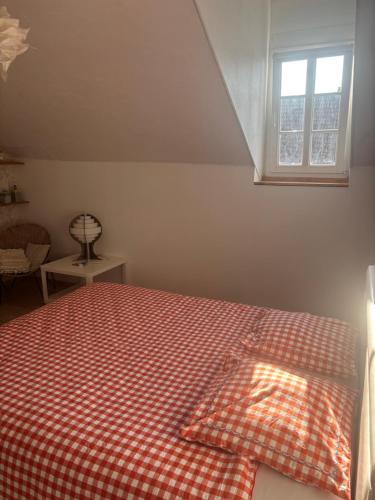 a bedroom with a bed with a red checkered blanket at Cine in Sainte-Menehould