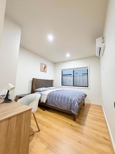 a bedroom with a bed and a desk and a window at Comfort Suite with Ensuite Bathroom in Wyndham Vale