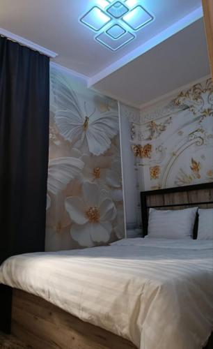 a bedroom with a bed with a flower wallpaper at Апартаменты in Jermuk