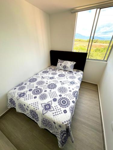 a small bedroom with a bed with a floral bedspread at Apartamento modero nuevo, 3 habitaciones y parqueadero en conjunto in Neiva