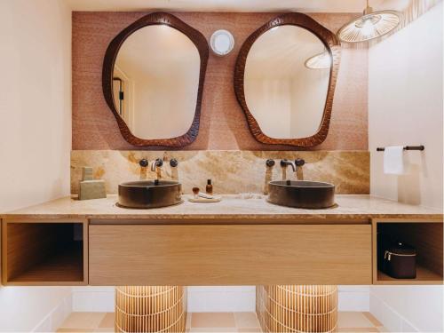 ein Badezimmer mit zwei Waschbecken und zwei Spiegeln in der Unterkunft Hyde Perth in Perth