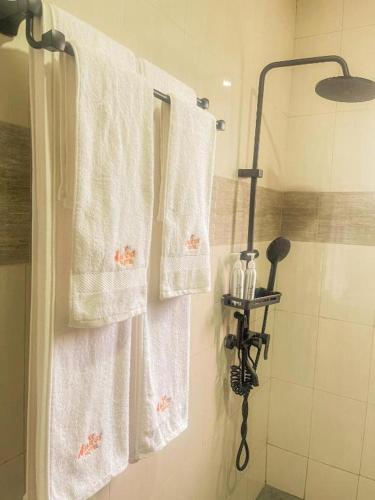 a bathroom with white towels hanging from a shower at VEGAS Motel in Kigali