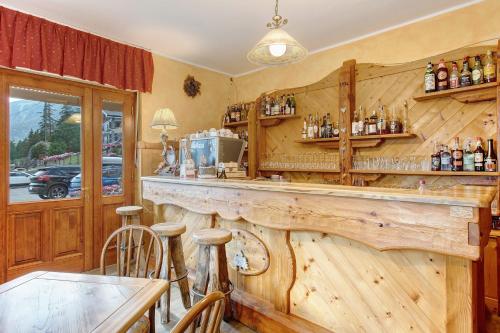 a bar in a restaurant with a wooden wall at Hotel Valentino - Bionaz in Bionaz