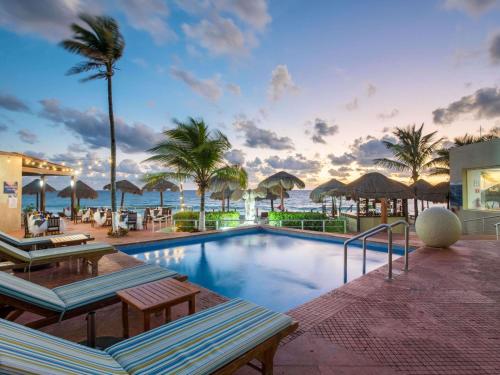 a swimming pool with a view of the ocean at Club Regina Cancun in Cancún