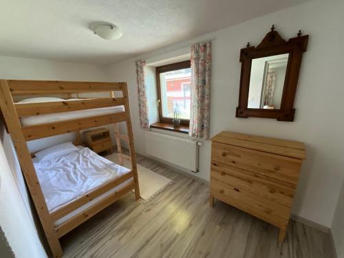 a bedroom with two bunk beds and a mirror at Vidiecky domček in Pohronská Polhora