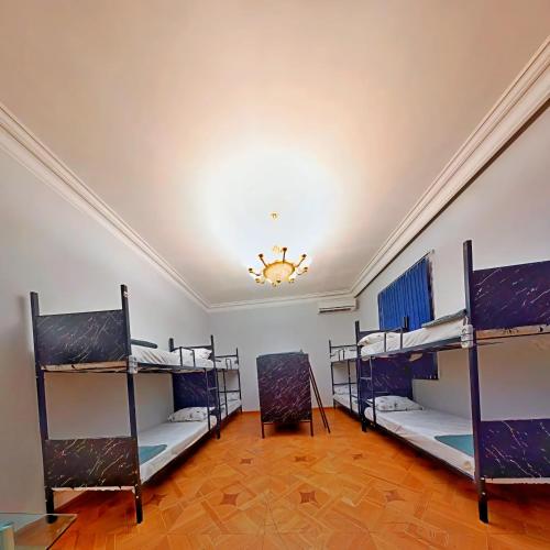 a room with three bunk beds and a chandelier at Olympic Hostel in Yerevan