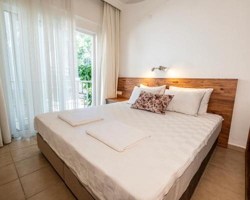 a bedroom with a large bed with a wooden headboard at Kemer House Apartments in Kemer