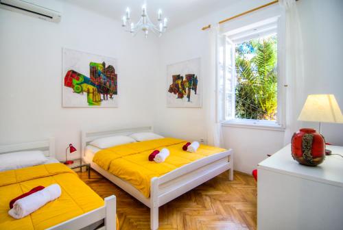 1 dormitorio con 2 camas y ventana en Villa Martinis, en Split