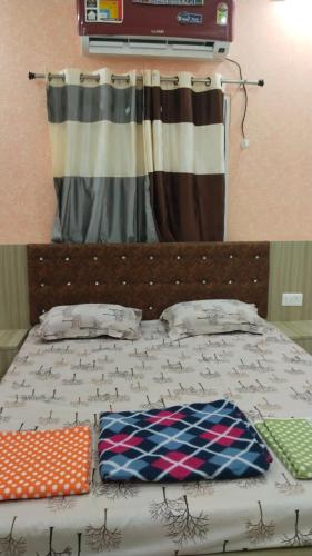 a bed with two pillows on it with a curtain at Shravan Hotel in Rāmgarh