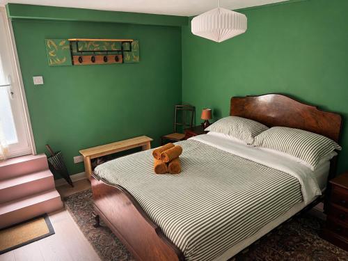 a teddy bear sitting on a bed in a bedroom at Little B - Artist owned boutique apartment near Southsea beach in Portsmouth