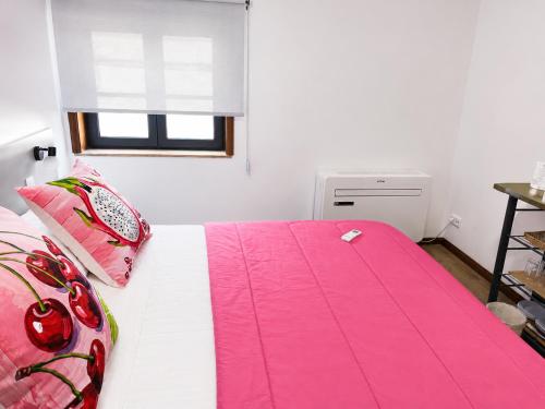 a bedroom with a large bed with pink sheets at Aveiro Ria View in Aveiro