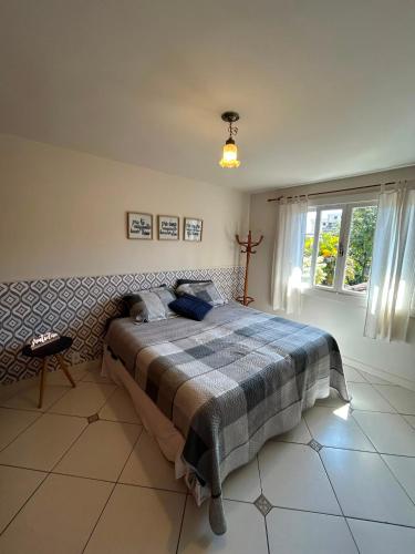 a bedroom with a bed with a checkered blanket at Cantinho na Serra in Teresópolis