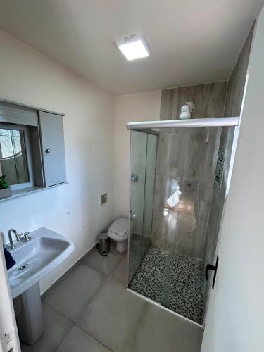 a bathroom with a shower and a sink and a toilet at Cantinho na Serra in Teresópolis