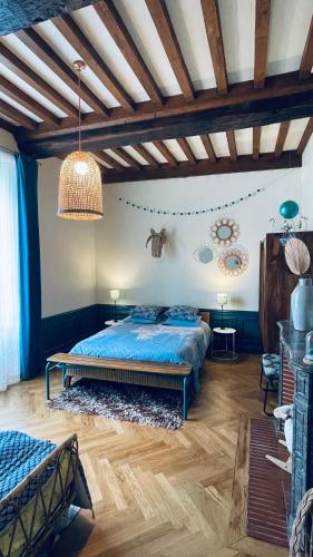 a bedroom with a blue bed and a ceiling at La Closerie Teranga in Bayeux