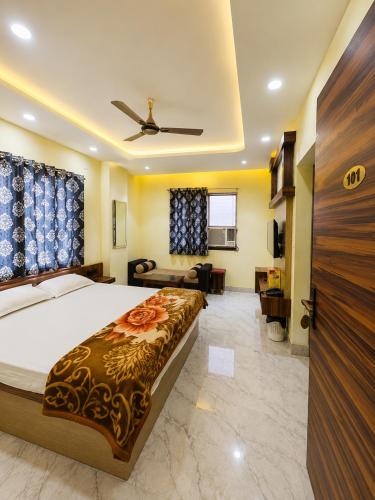 a bedroom with a large bed and a living room at Hotel Shree Radhe & Banquet in Darbhanga